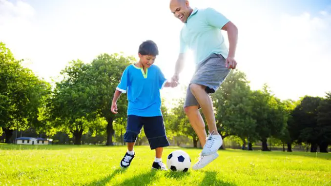 Little Boy Playing Soccer With His Father
